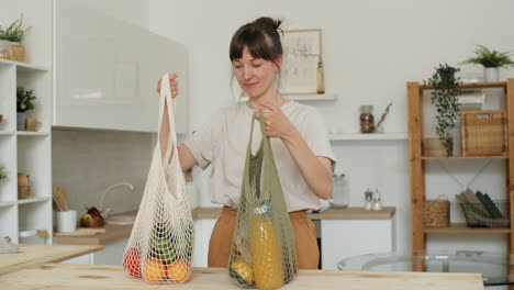 Woman-Unloading-Groceries-from-Net-Bags-in-Kitchen